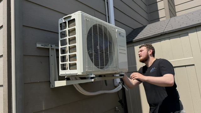 API inspector servicing an outdoor air conditioning condenser unit